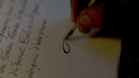Gif (imagem com movimento), de uma pessoa assinando uma carta. Só aparece a mão da pessoa realizando o movimento da escrita e a parte inferior direita da folha.